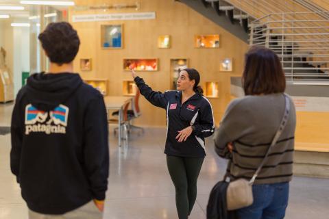 An student tour guide takes visitors on a campus tour