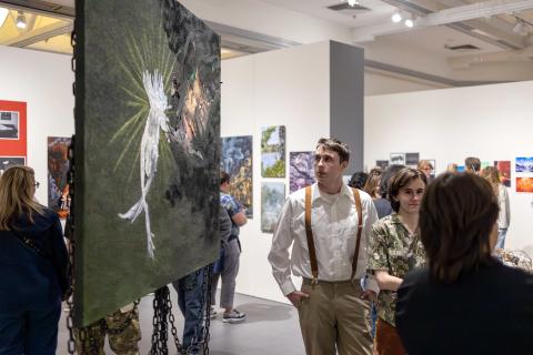 An attendee of the Art and Design Showcase views student artwork