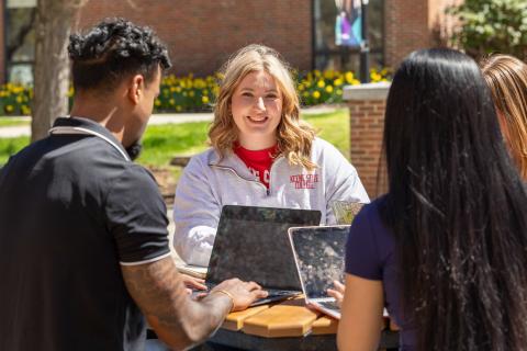 Student smiling while sitting outdoors